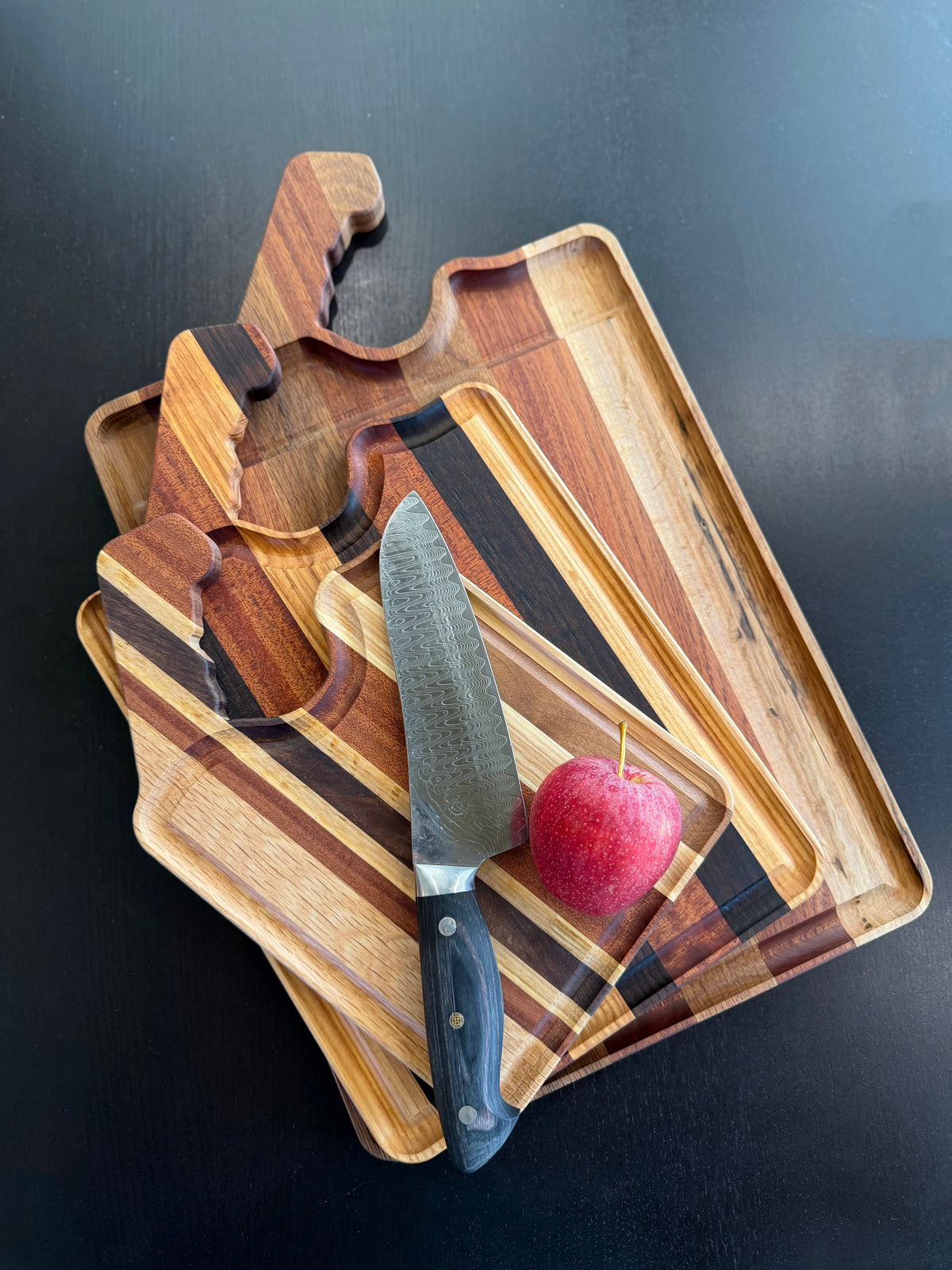 Hardwood cutting boards in small, medium, and large sizes with a Damascus knife and apple